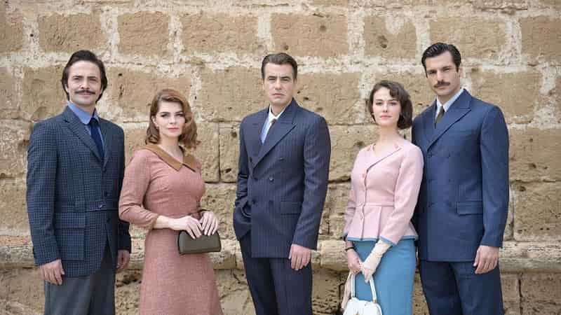 cover bir zamanlar kibris. three men wearing blue suits, one lady wearing pink-red dress, second lady wearing white shirt and blue skirt