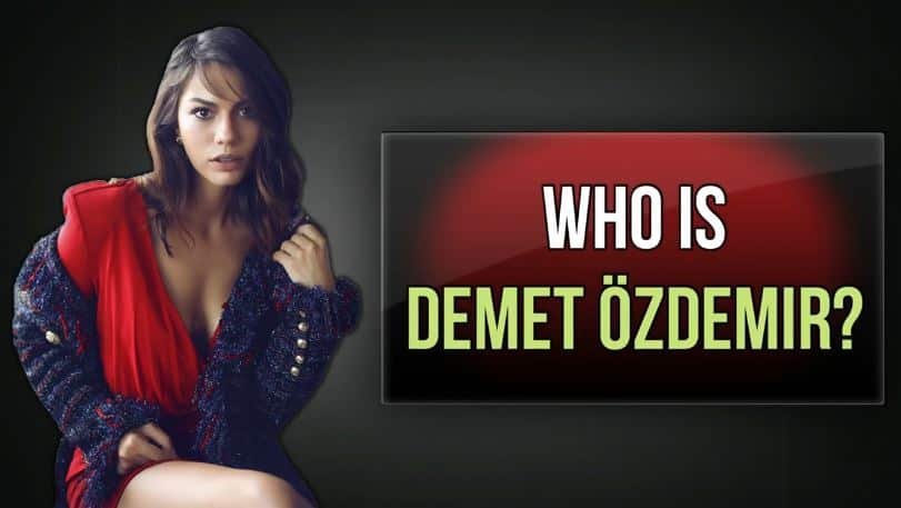 demet ozdemit wearing a red dress and a blue jacket, playing with her black hair with a big font in white and yellow who is demet ozdemir 30 facts every fan should know