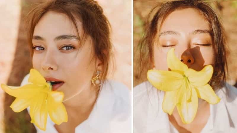 neslihan atagül wearing a white shirt with brown hair, showered by sun rays holding a yellow flower in her mouth, ah belinda netflix