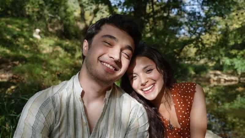 Güzel Günler dizi series burak dakak wearing a bright shirt smiling in nature with leyla tanlar holding her head on his soulder smiling