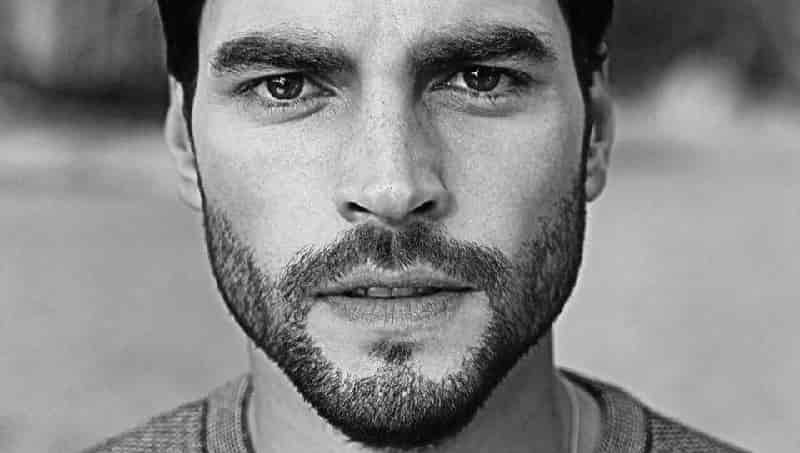 handsome turkish actor Akın Akınözü face close up with beard and deep dark eyes, black and white for IVI in Moscow while tuzak final come soon