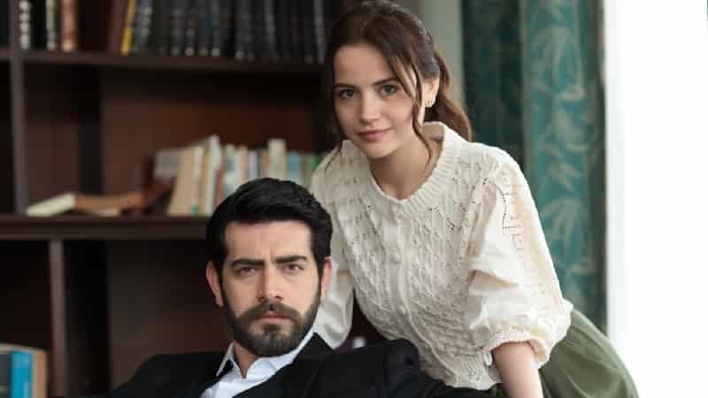 Kan Çiçekleri starring Barış Baktaş and Yağmur Yüksel aka Dilan wearing a white shirt staying behind her husband baran