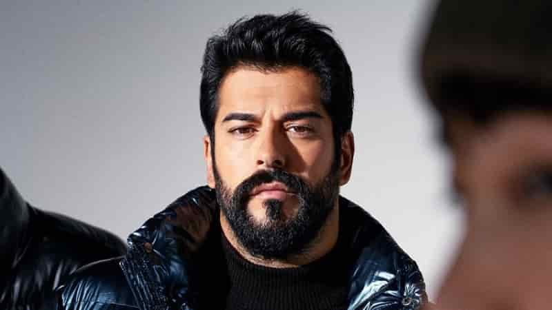 close up face of burak özçivit with beard and dark hair wearing a black jacket in the new netflix turkish movie 2023 berber with mert yazıcıoğlu